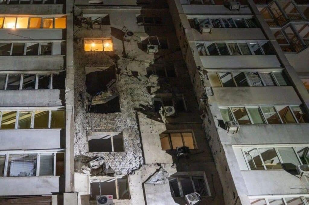 Багатоповерховий житловий будинок з проломом у стіні та вибитими вікнами після удару російського дрона в Одесі вночі