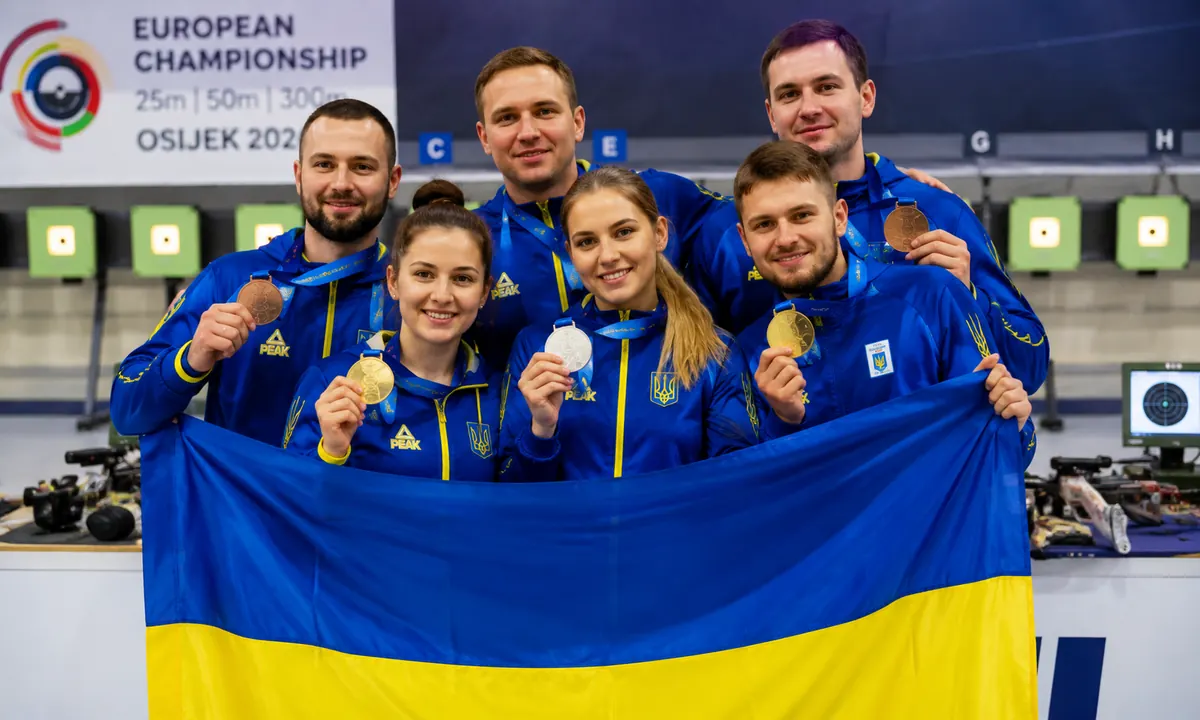 Українські спортсмени зі стрільби тримають медалі та прапор України після успішного виступу на Євро-2026